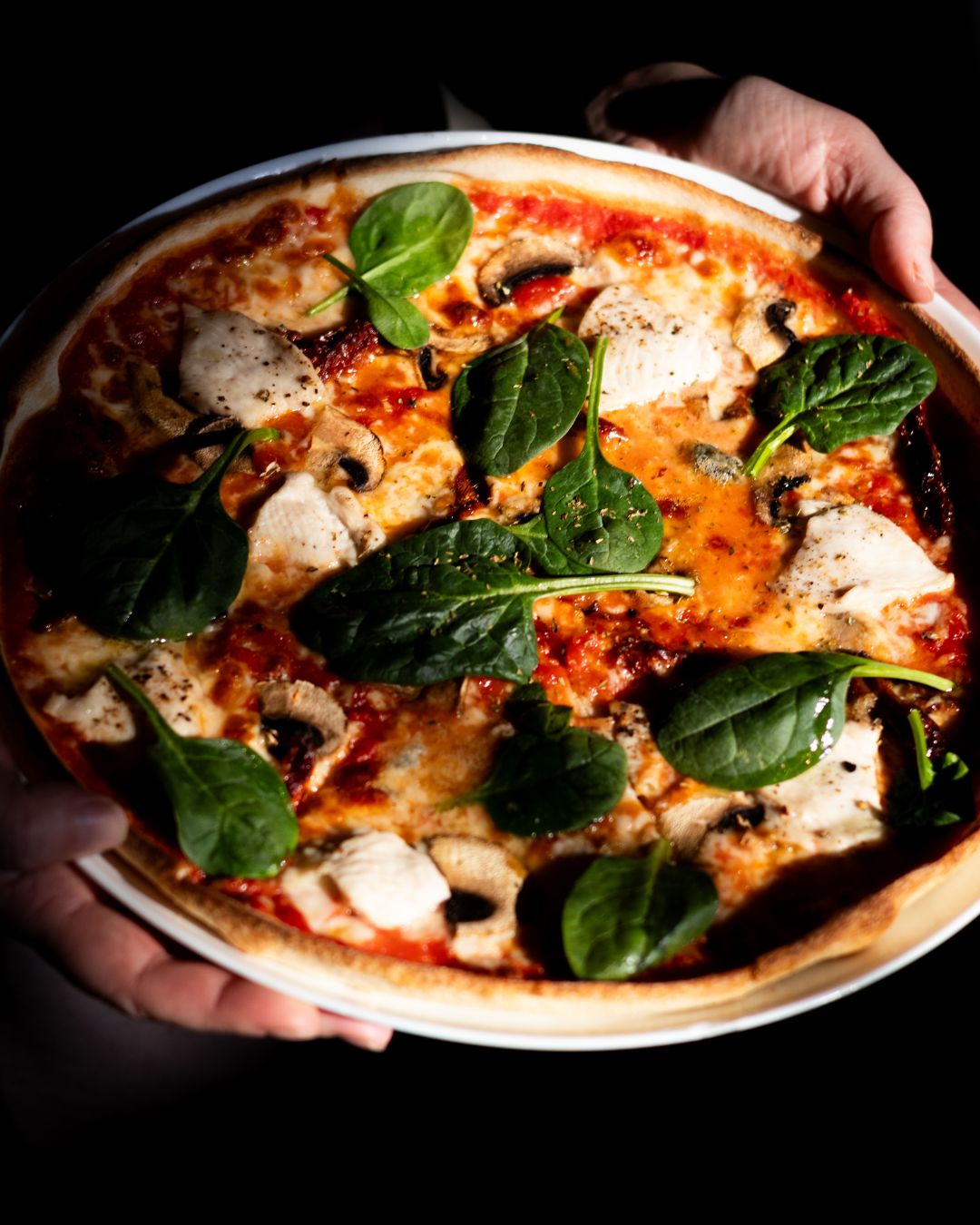 Pizza na czarnym tle — fotografia kulinarna